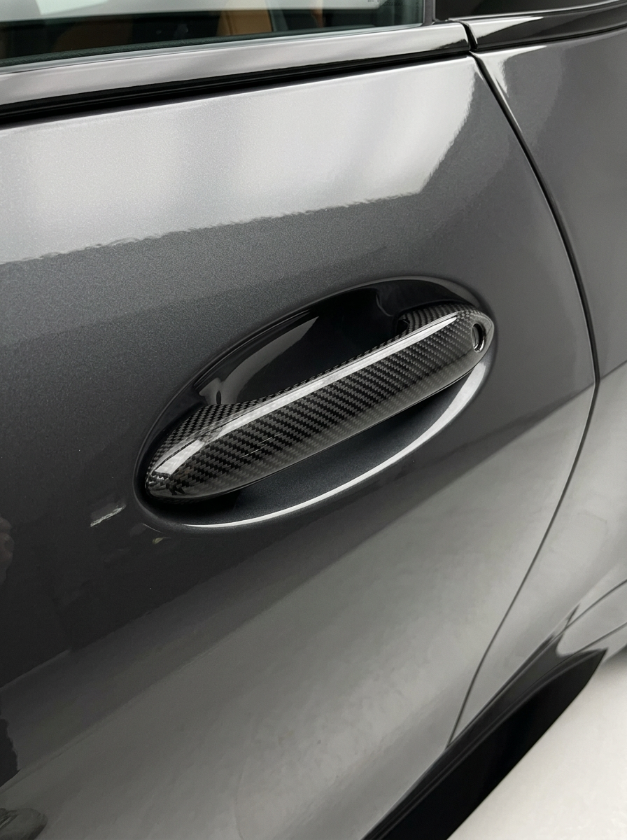 BMW 4 Series G82 M4 carbon fiber door handle cover by K2 Industries, sleek black textured finish on car door handle.