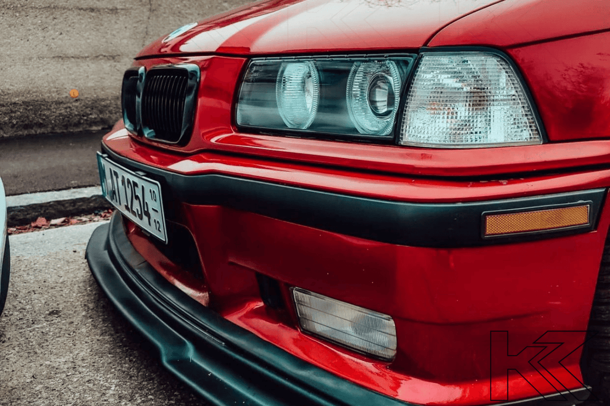 BMW 3 Series E36 sedan LED headlights with black angel eyes by K2 Industries, showcasing the front view with illuminated rings.