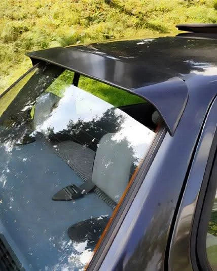 Black BMW E30 3 Series roof spoiler by K2 Industries, fits 1982-1994 models, mounted on the car's rear roof area.