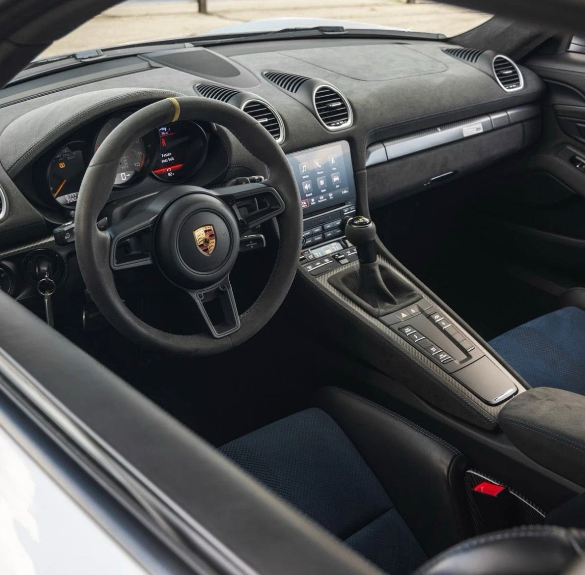 Red manual Porsche 991.2 steering wheel by Boston Motortech with detailed grip and branding visible.