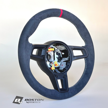 Red manual Porsche 991.2 steering wheel by Boston Motortech with grip details and mounting hardware visible.