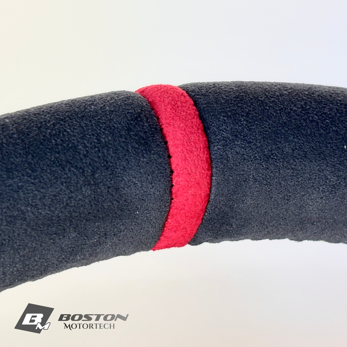 Red manual Porsche 991.2 steering wheel interior trim by Boston Motortech, showcasing a sleek, sporty design with detailed stitching.