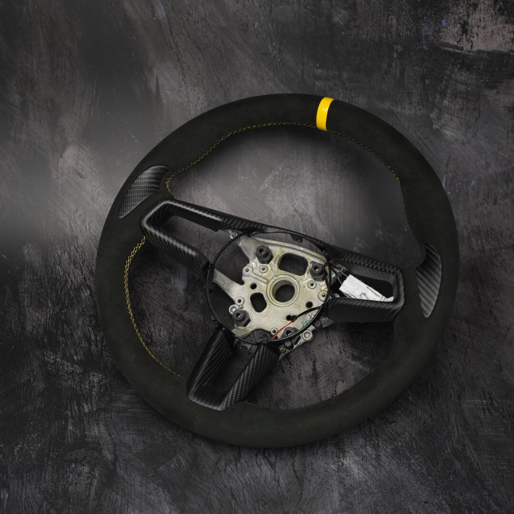 Custom Porsche 911 (992), Taycan, Macan steering wheel by Exclusive Steering featuring black leather and silver accents.