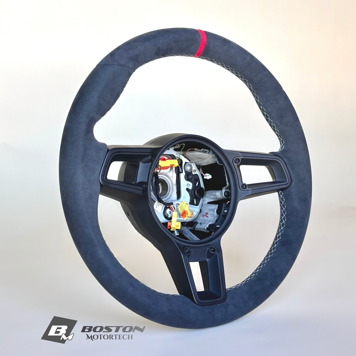 Red manual Porsche 991.2 steering wheel by Boston Motortech, featuring textured grip and detailed stitching.