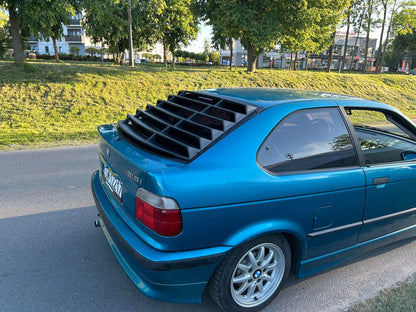 BMW E36 Compact Series 3 black back windshield louvers by K2 Industries, shown on the rear window of the car.