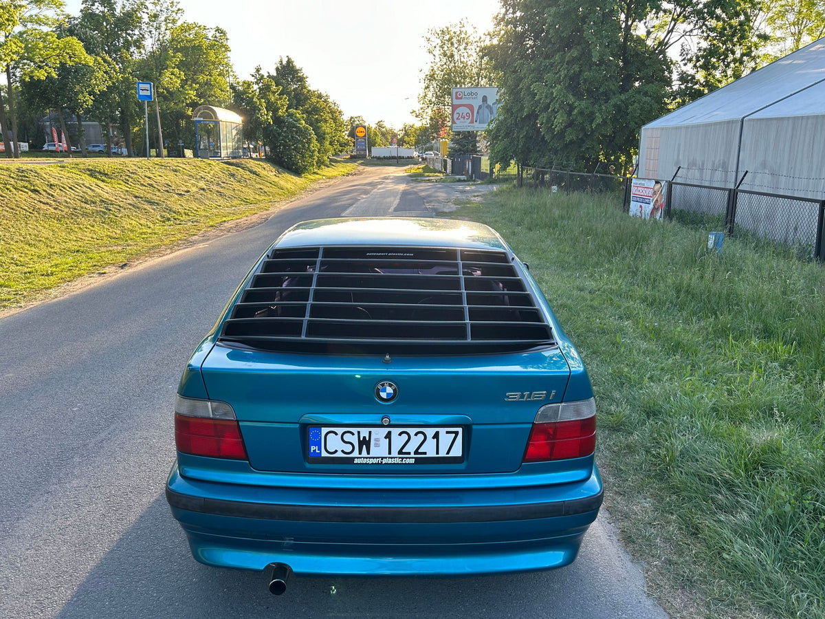 Black BMW E36 Compact Series 3 windshield louvers by K2 Industries, installed on the rear window of the 1992-1999 model.
