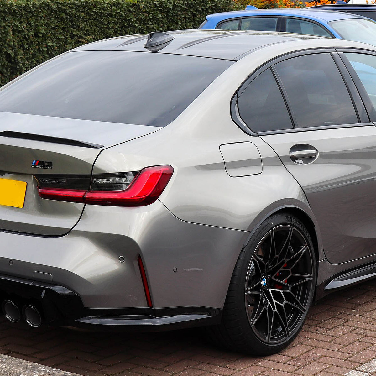 BMW G80 M3 and G82 M4 carbon fiber rear canard splitter flaps from Palenon Performance, mounted on the rear of a 2021 BMW M3 Competition.
