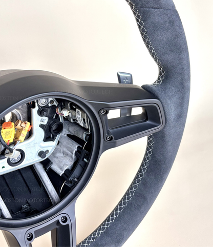 Red PDK Porsche 991.2 steering wheel by Boston Motortech, featuring leather grips and integrated control buttons.