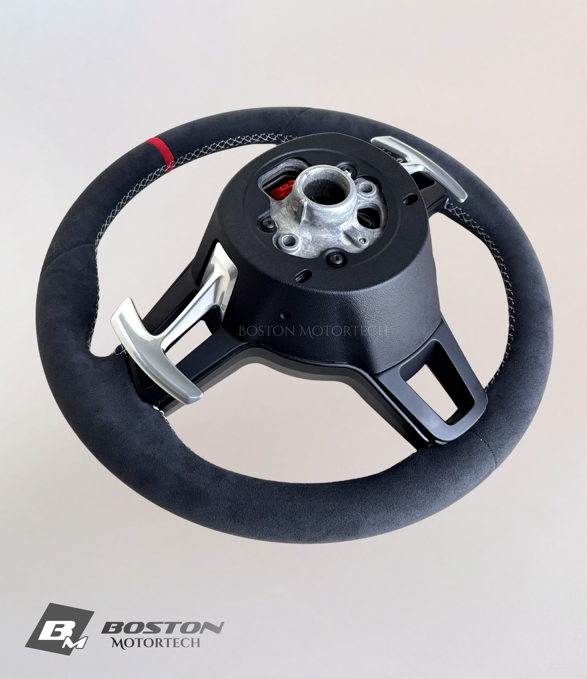 Red PDK Porsche 991.2 steering wheel by Boston Motortech, featuring leather grip and control buttons, viewed from the front angle.