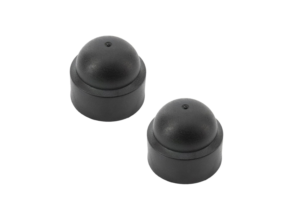 Pair of GoWesty pivot bolt caps for Vanagon rear suspension, shown in black with metal bolt holes for secure fit.