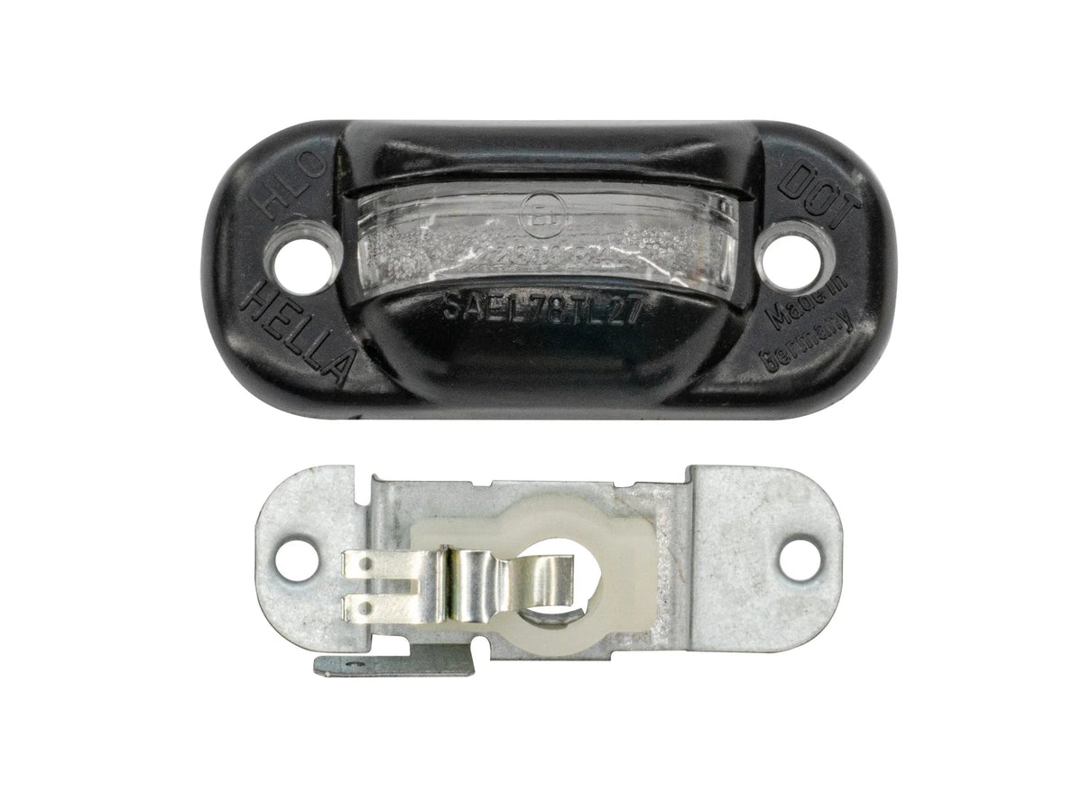 GoWesty Vanagon license plate light bulb holder and lens, showcasing the lighting component with clear lens and metal holder.