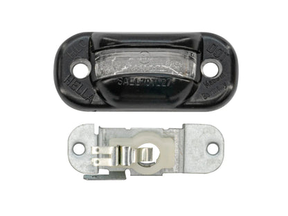 GoWesty Vanagon license plate light bulb holder and lens, showcasing the lighting component with clear lens and metal holder.