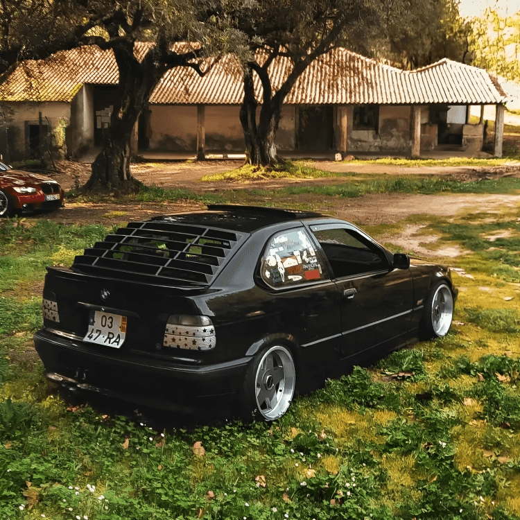 Black BMW E36 Compact Series 3 windshield louvers by K2 Industries, designed for 1992-1999 models, mounted on the rear window.