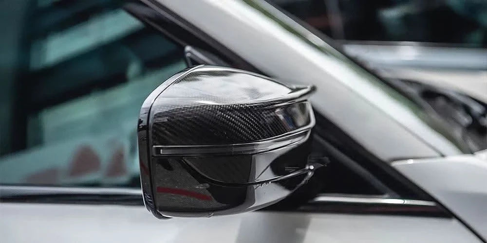 BMW 2 Series G87 and 3 Series G20/G28 M3 style carbon fiber side mirror housing by K2 Industries, featuring sleek carbon fiber finish.