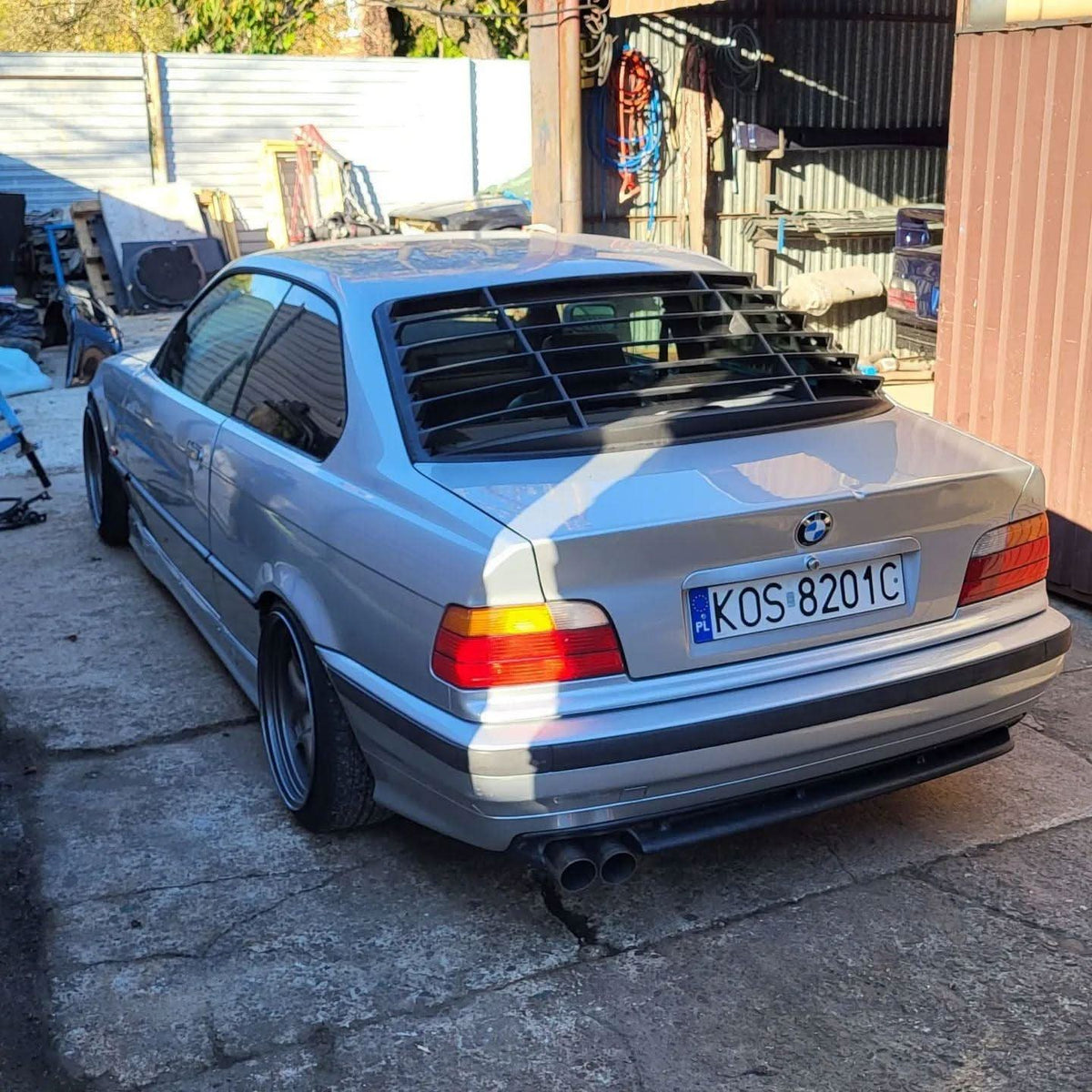 BMW E36 Coupe Series 3 black windshield louvers by K2 Industries, showing the louver design on the rear windshield of the car.