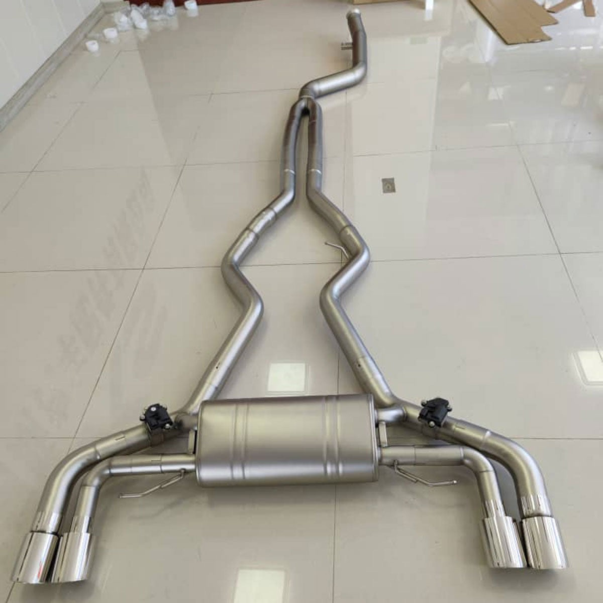 Palenon Performance B58 BMW G22 M440i and G20 M340i catback exhaust system installed on a vehicle, showcasing polished metal exhaust pipes.