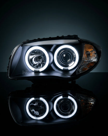 BMW 1 Series E87 headlights with Angel Eyes LED bulbs from K2 Industries, showcasing the front view with illuminated rings.