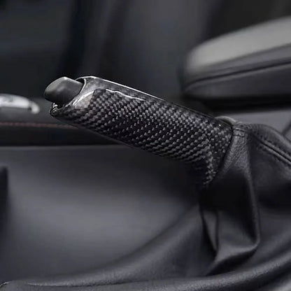 BMW carbon fiber handbrake lever cover by K2 Industries, showing sleek black carbon fiber material on a handbrake lever.