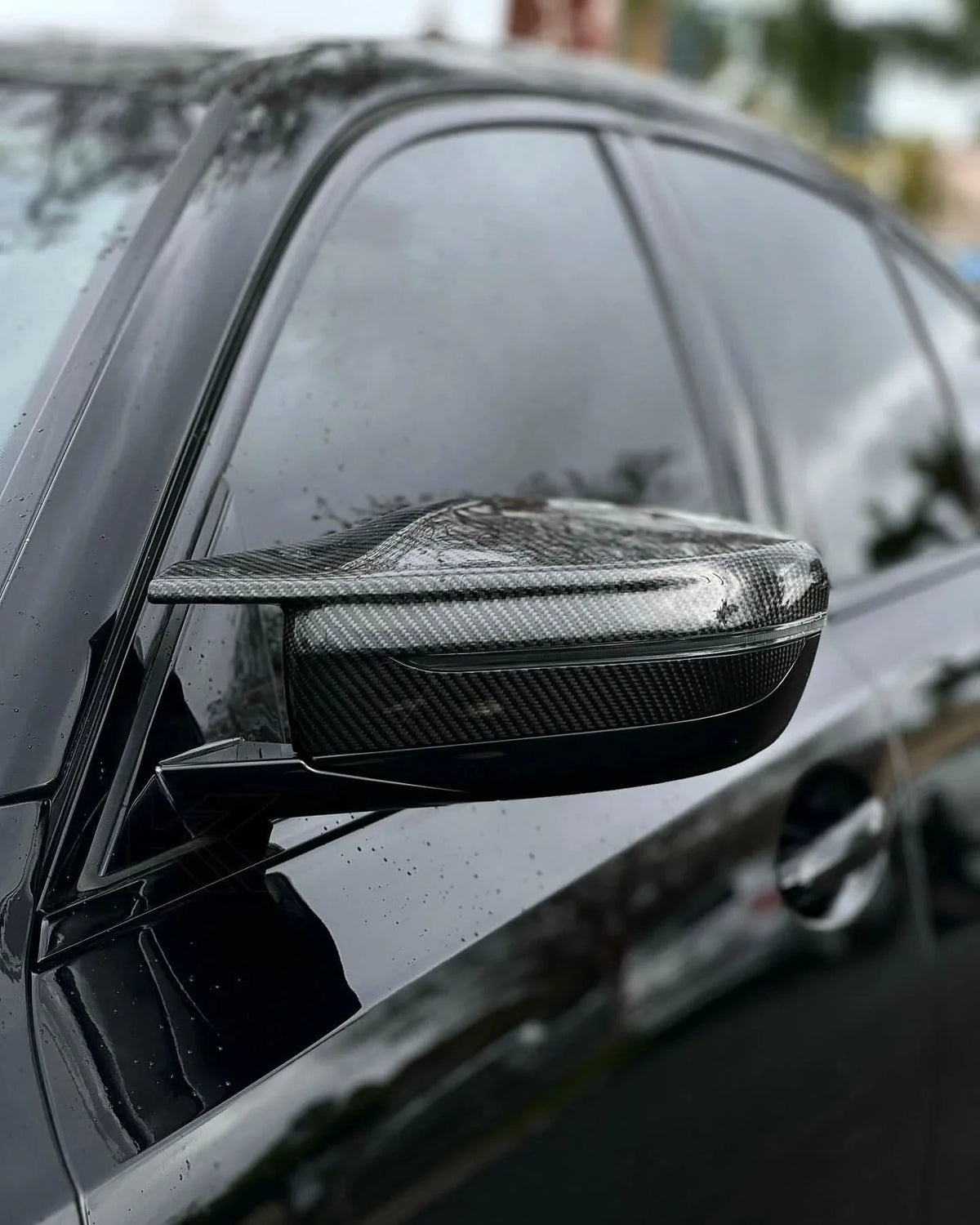 BMW 2 Series G87 and 3 Series G20/G28 M3 style carbon fiber side mirror housing by K2 Industries, showing sleek glossy finish.