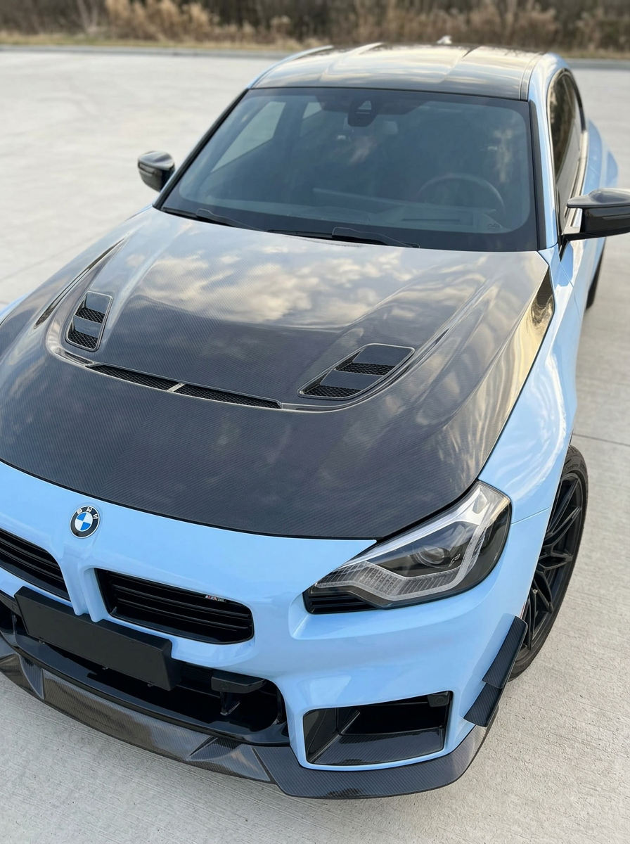 BMW 2 Series G87 M2 carbon fiber hood by K2 Industries, showing sleek, lightweight carbon fiber surface with vents and smooth finish.