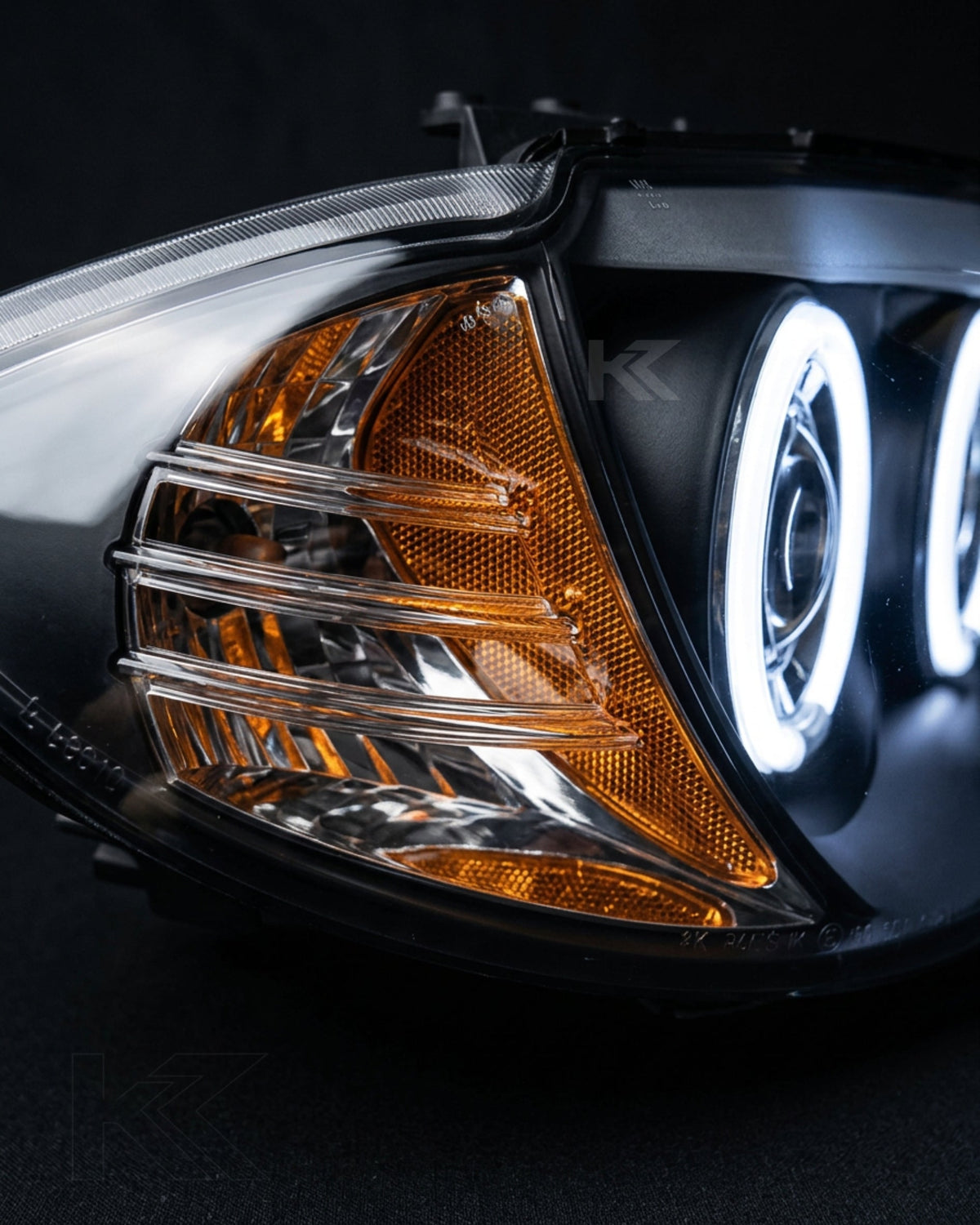 BMW 1 Series 120i E87 headlights with LED angel eyes, manufactured by K2 Industries, showing clear lens and integrated LED rings.