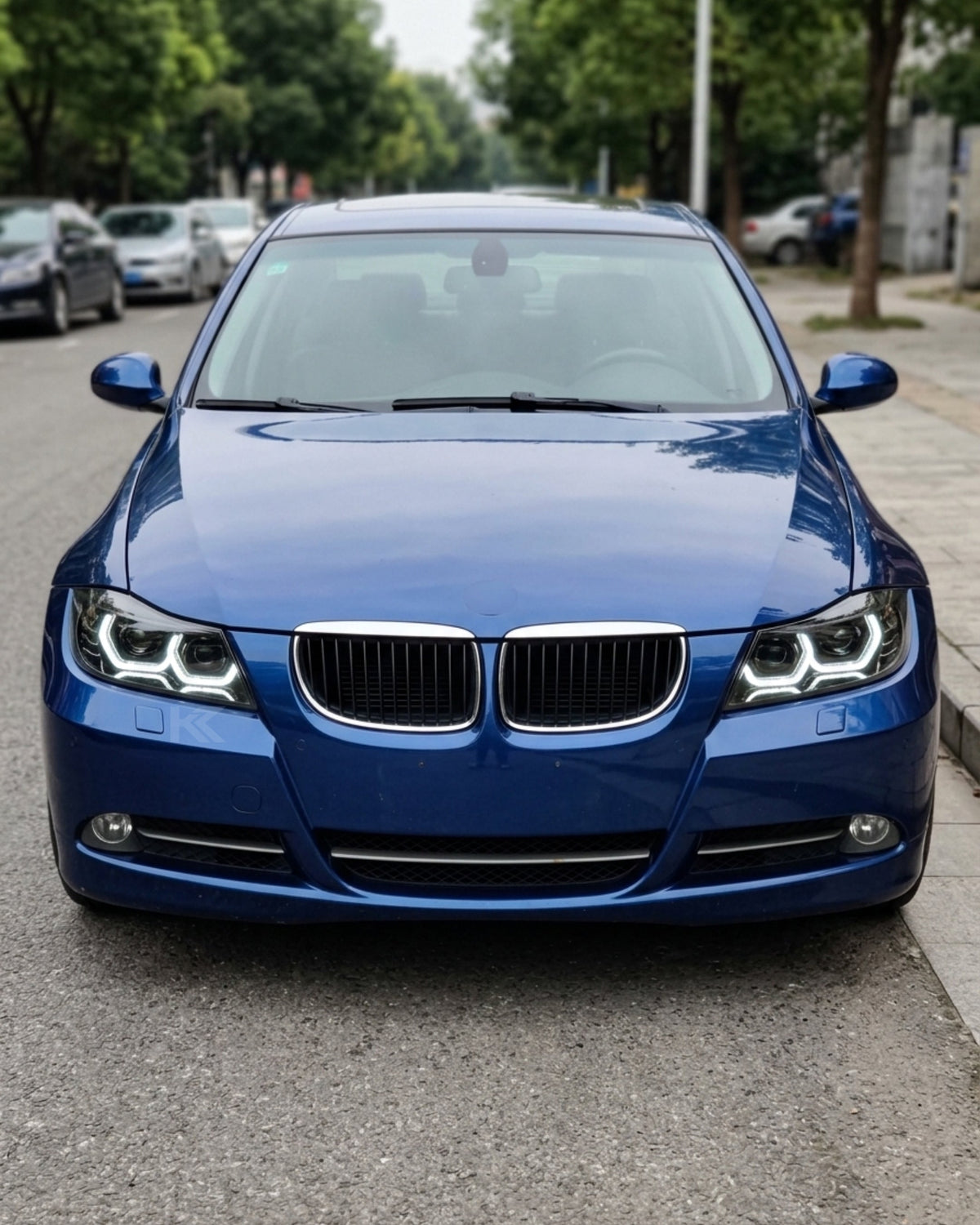 BMW 3-Series E90/E91 headlights with "TRON" design by K2 Industries, featuring sleek clear lenses and modern styling.