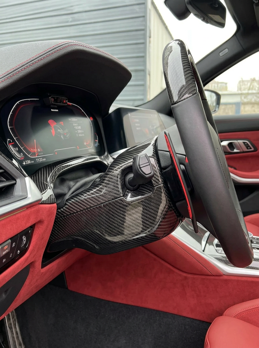 BMW 3 Series G80 G81 M3 and 4 Series G82 G83 M4 carbon fiber steering column cover by K2 Industries, close-up view of the sleek design.