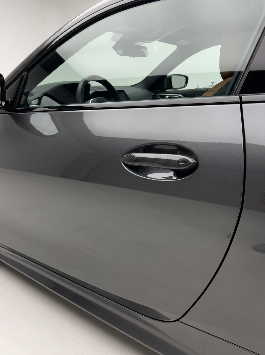 BMW 4 Series G82 M4 carbon fiber door handle cover by K2 Industries, showcasing sleek black textured finish on car door handles.