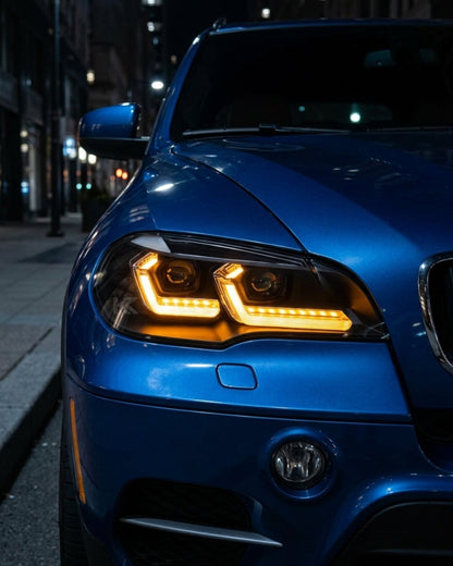 BMW X5 E70 headlights with K2 Industries "TRON" LED design installed, showing the front view with clear lens and LED accents.