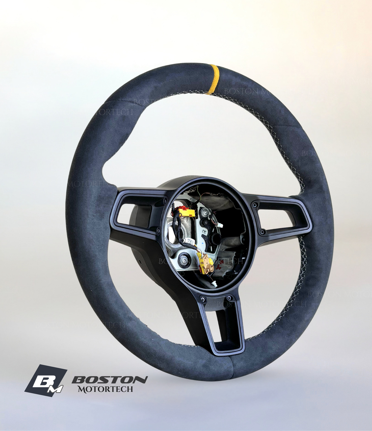 Yellow manual Porsche 991.2 steering wheel by Boston Motortech with black accents, detailed view of the sporty car interior component.