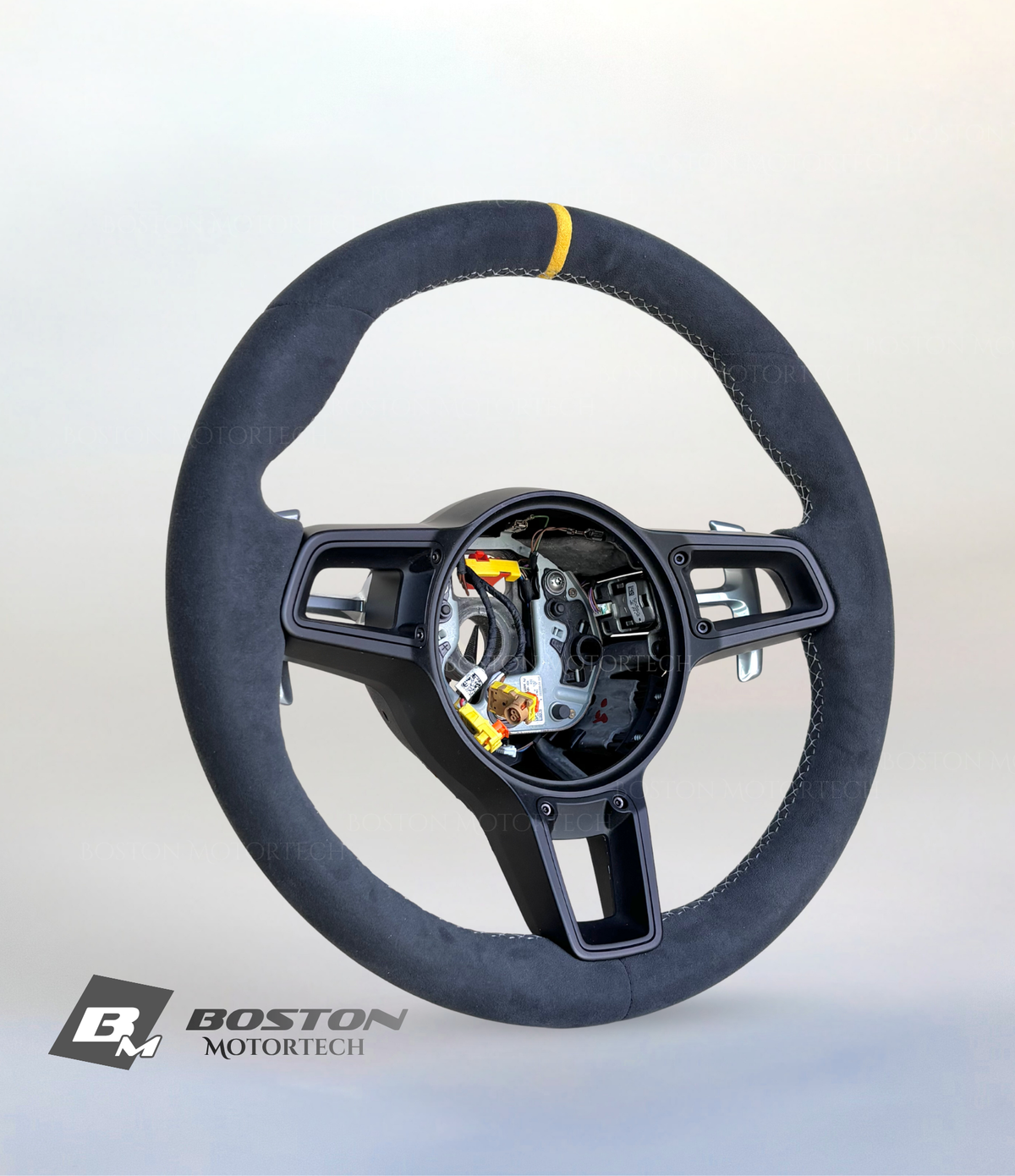 Yellow PDK Porsche 991.2 steering wheel by Boston Motortech, showing close-up of textured leather grip and sleek design.