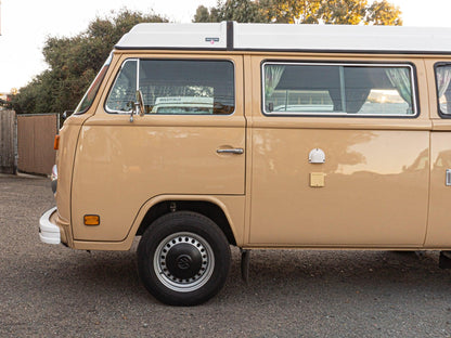 Black 15-inch steel wheel set for 2WD and 4WD Bus or Vanagon by GoWesty, shown mounted on vehicle.