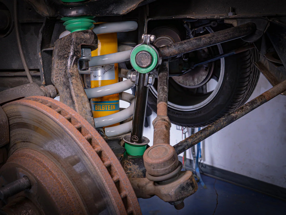 GoWesty Vanagon front sway bar bushing bundle installed, showing bushings and suspension components in a vehicle undercarriage.