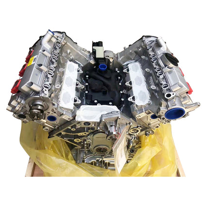 A NEW AUDI VW EA897 V6 TDI CATA silver and black automotive engine block with blue gasket material, photographed inside a cardboard shipping box with plastic wrap.