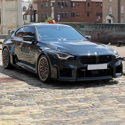 Carbon fiber M style front lip for BMW M2 G87, designed by Palenon Performance, shown in black with aerodynamic contours.