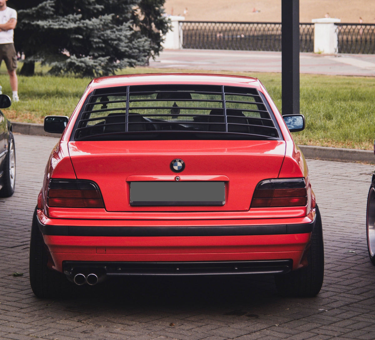 Black BMW E36 Coupe Series 3 windshield louvers by K2 Industries, designed for 1992-1999 models, shown installed on the rear window.
