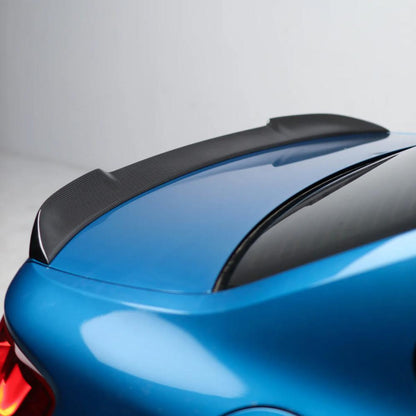 Carbon fiber BMW F87 M2 and F22 CS style trunk spoiler by Palenon Performance showcasing sleek, aerodynamic design on a sporty car.