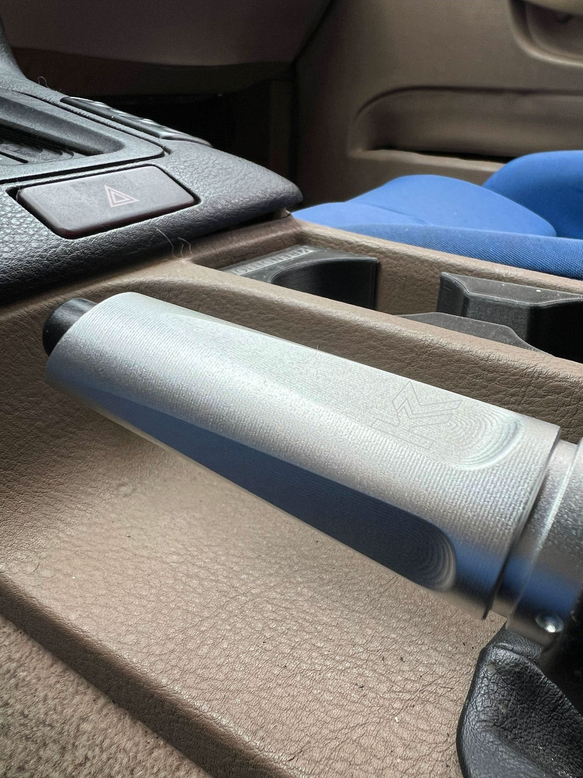 BMW aluminum handbrake cover by K2 Industries, showing a sleek, metallic hand brake cover fitted in a vehicle interior.