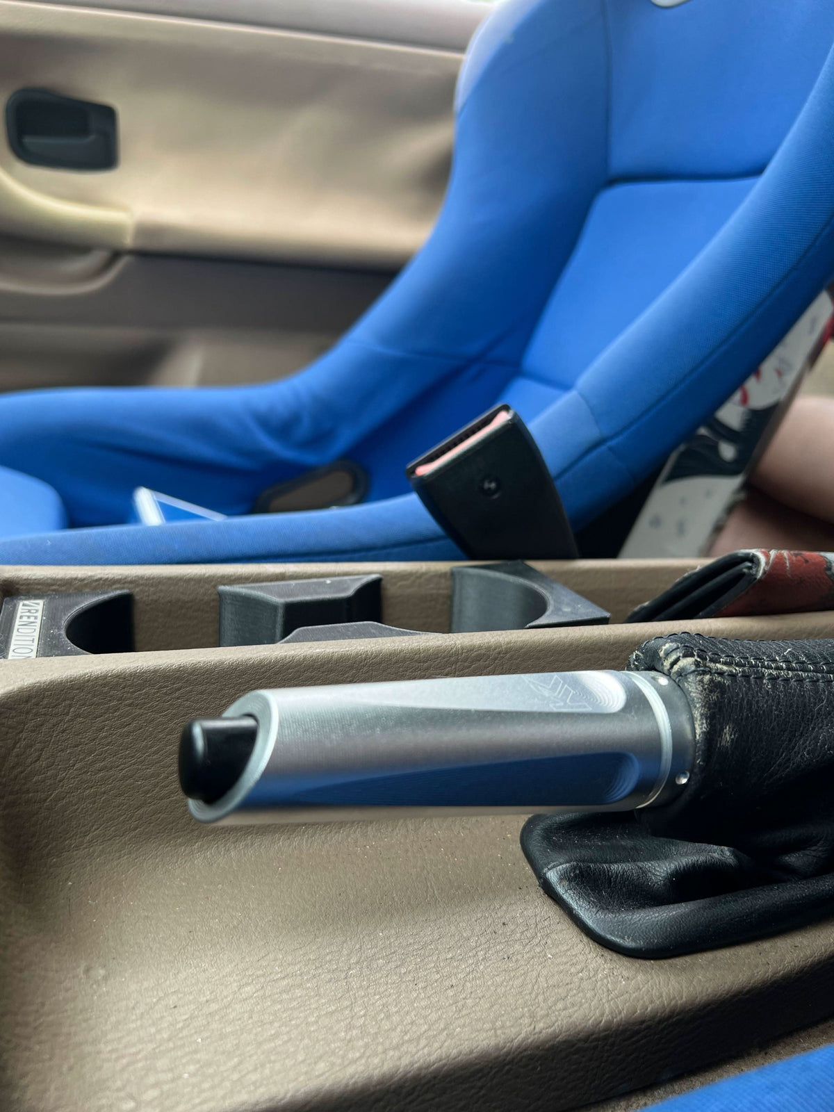 BMW aluminum handbrake cover by K2 Industries, showing a sleek, metallic hand brake cover with textured finish.