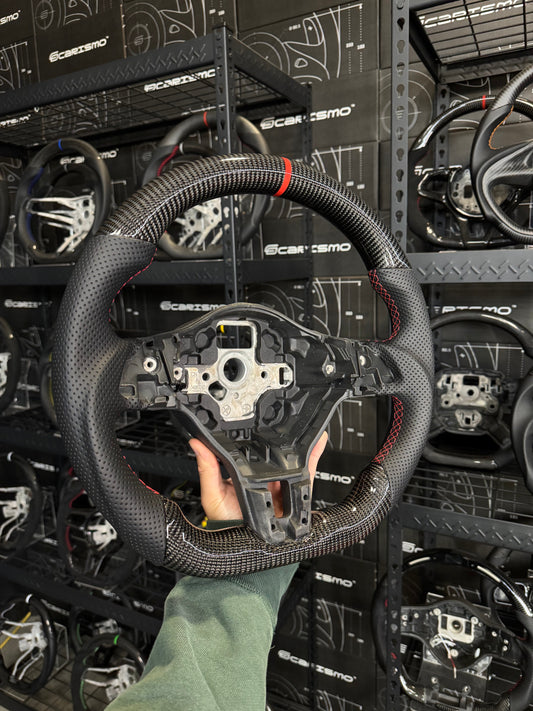 Carismo sport steering wheel for Volkswagen Golf MK6 with gloss carbon finish and perforated leather grips.