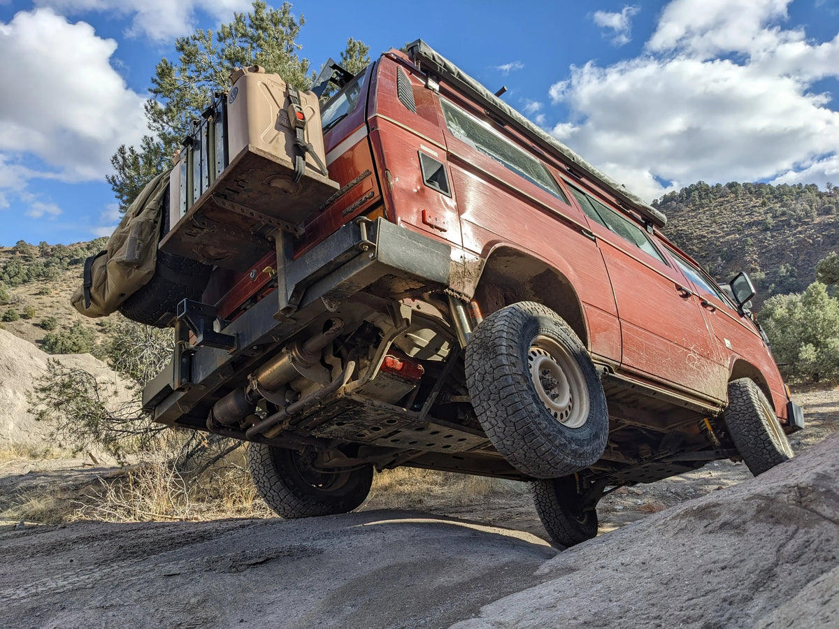 Rear 23-inch GoWesty Suspension Limit Strap Set for 2WD Vanagon, shown installed with suspension components at night.