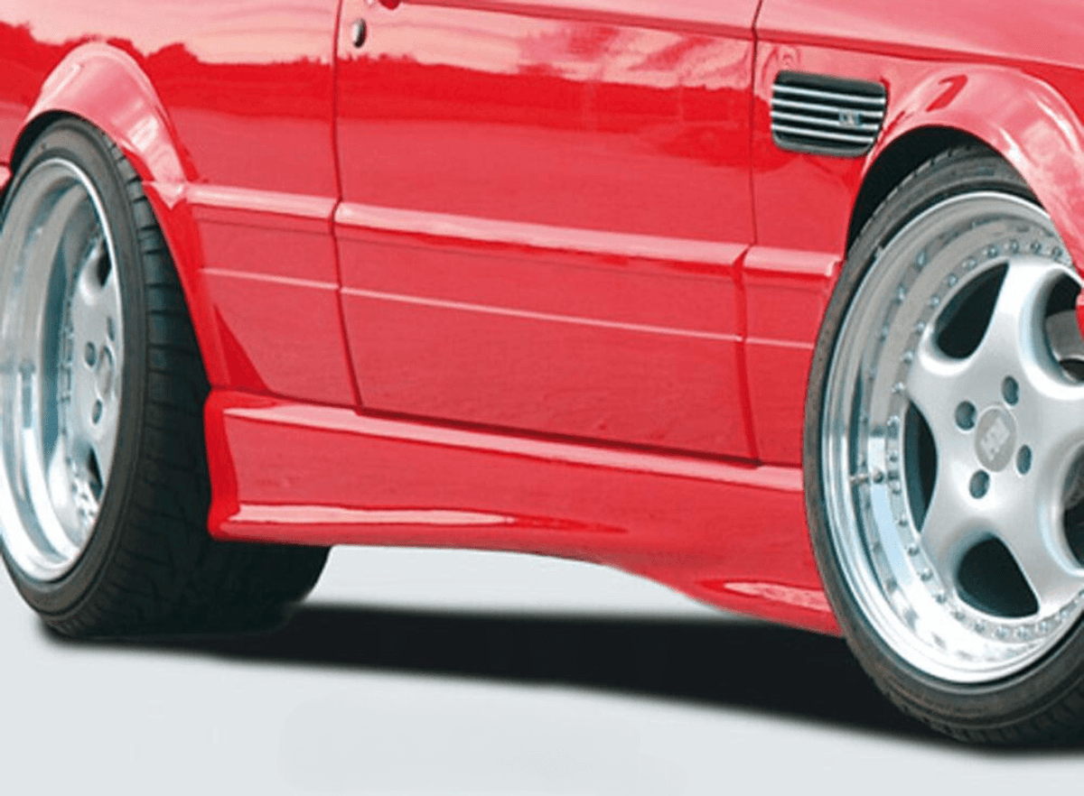 K2 Industries BMW E30 Sedan/Wagon side skirts V2 installed on vehicle, showcasing sleek aerodynamic design and fitment details.