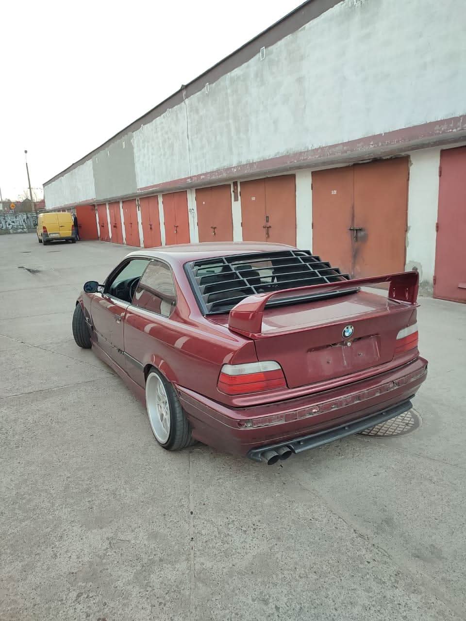 Black BMW E36 Coupe series 3 windshield louvers by K2 Industries, installed on the rear window for a sporty look.