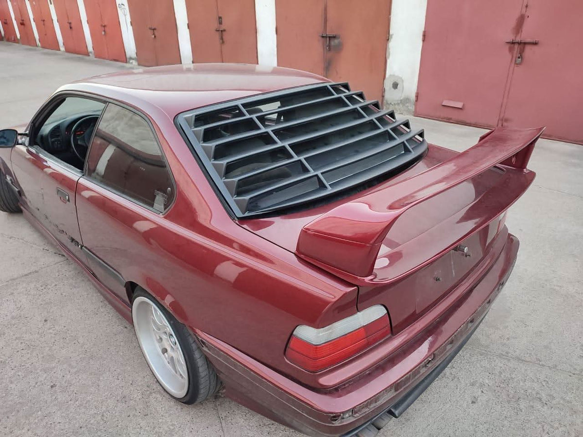 Black BMW E36 Coupe Series 3 windshield louvers by K2 Industries, installed on the rear windshield of the 1992-1999 model.