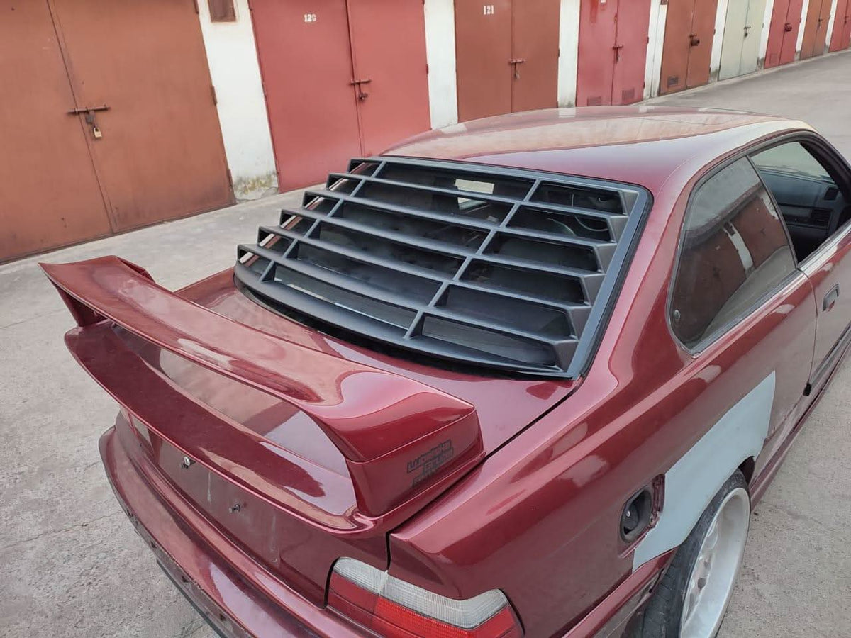Black BMW E36 Coupe Series 3 windshield louvers by K2 Industries, installed on the rear window of 1992-1999 model.