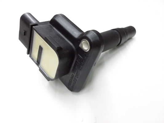 Genuine OEM ignition coil for Audi VW 1.8L and 4.2L engines, compatible with 1999-2004 models, shown in a car engine bay.