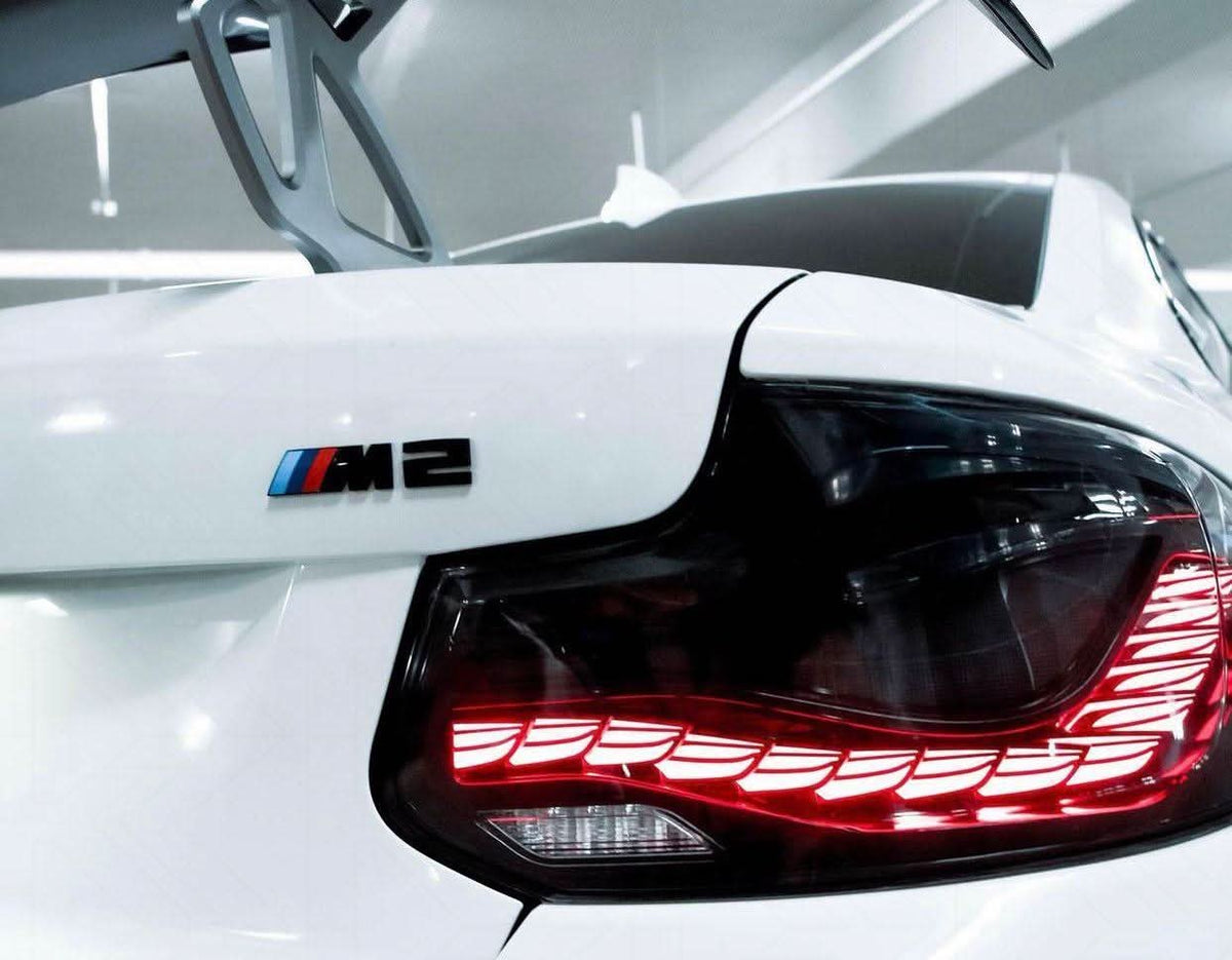 BMW 2-Series and M2 tail lights with red and black dragon scale OLED design by K2 Industries, showcasing intricate LED details.