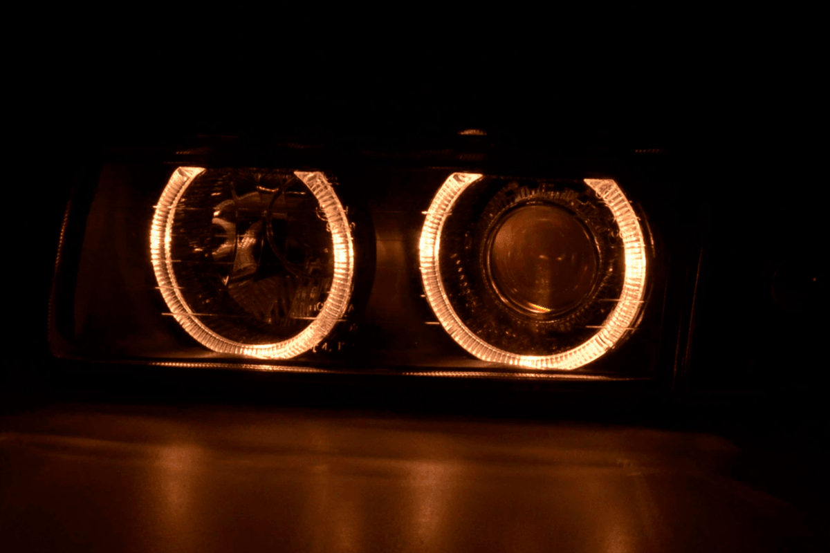 BMW 3 Series E36 sedan black angel eyes LED headlights by K2 Industries, 1992-1998 model, showcasing sleek headlight design.