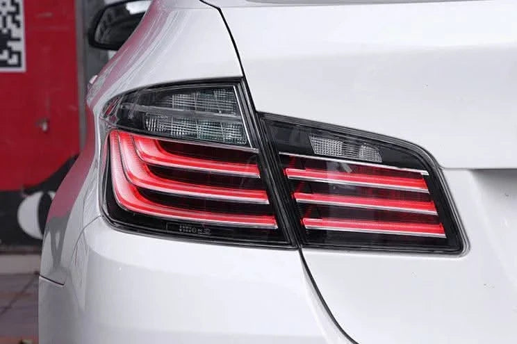 BMW 5-Series F10 clear style LED tail lights by K2 Industries, showcasing sleek design and bright illumination for model years 2010-2017.