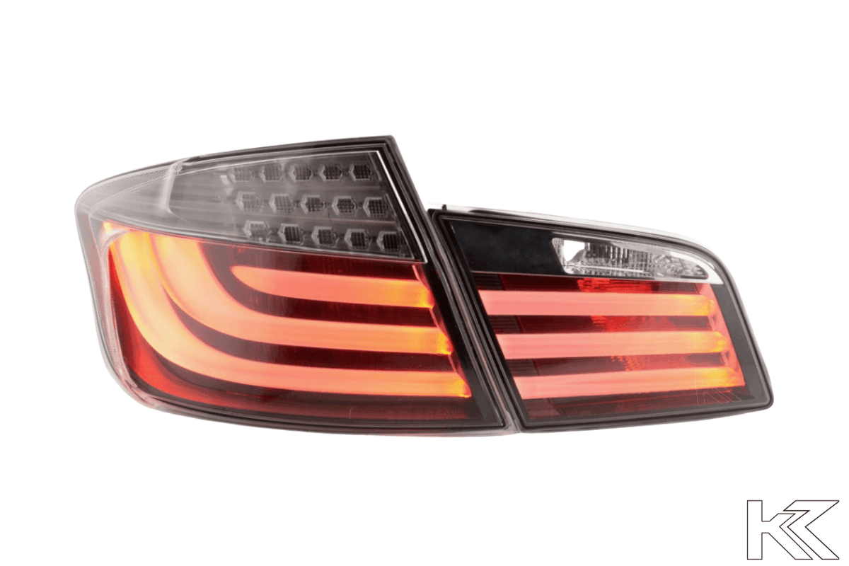 BMW 5-Series F10 sedan black LED tail lights by K2 Industries, installed on rear of 2010-2012 model, showing illuminated LED strips.